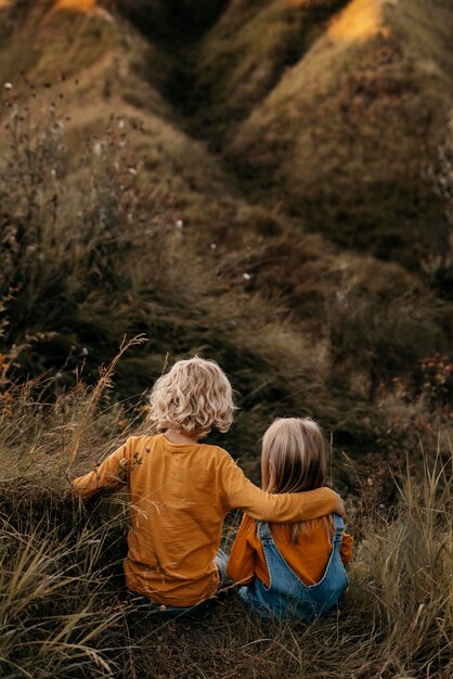 Niños de tiro completo sentados juntos en la hierba