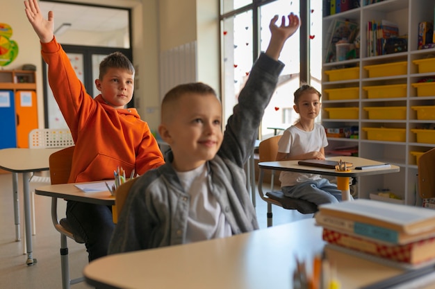 Foto gratuita niños de tiro medio aprendiendo en la escuela.