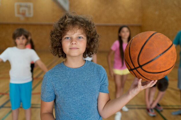 Niños de tiro medio con baloncesto