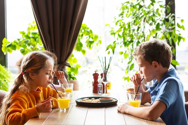 Niños de tiro medio bebiendo jugo