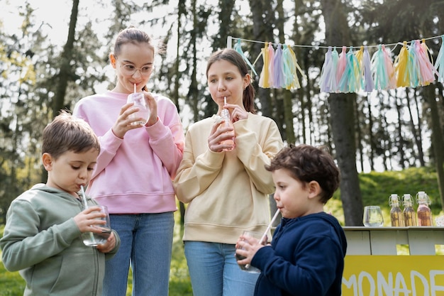 Foto gratuita niños de tiro medio bebiendo limonada