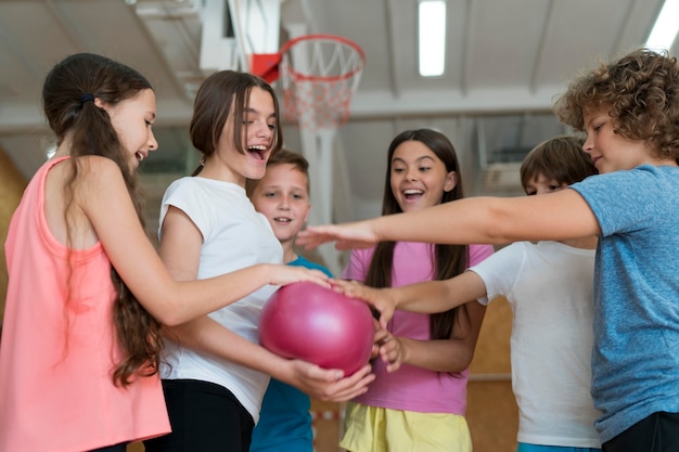 Niños de tiro medio con bola rosa