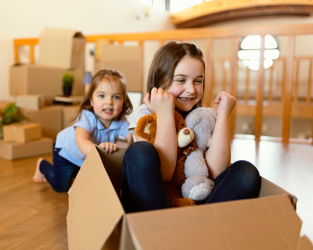 Niños de tiro medio con caja de cartón