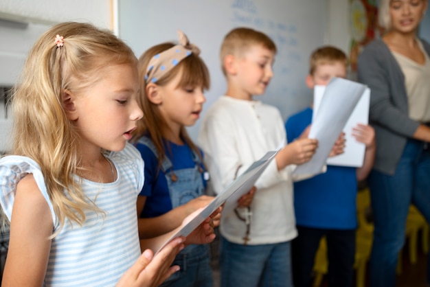 Niños de tiro medio cantando juntos en la escuela dominical