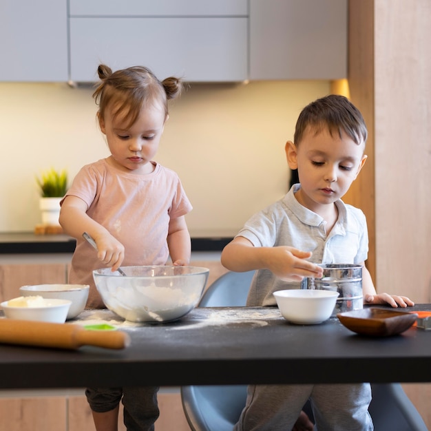 Niños de tiro medio en la cocina