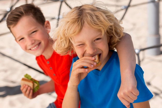 Foto gratuita niños de tiro medio comiendo sándwich