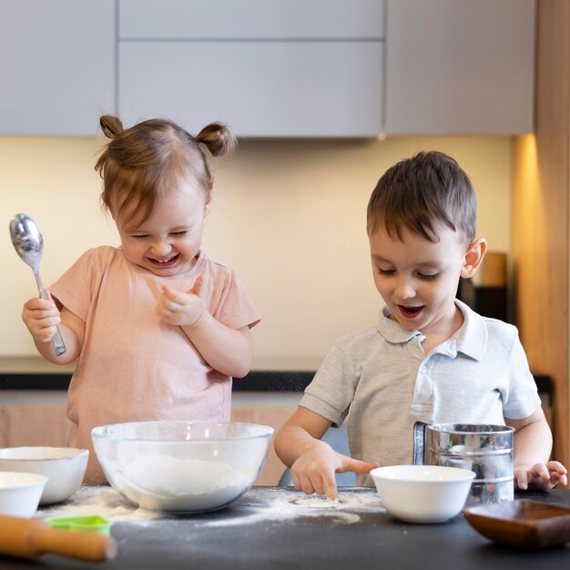 Niños de tiro medio divirtiéndose cocinando