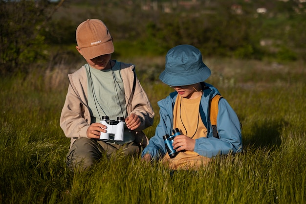 Niños de tiro medio explorando el entorno natural.