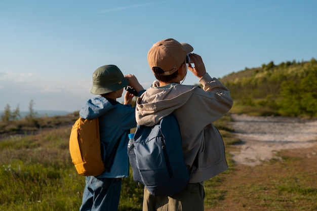 Niños de tiro medio explorando el entorno natural.