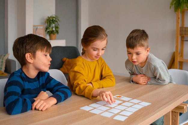 Foto gratuita niños de tiro medio jugando al juego de memoria.