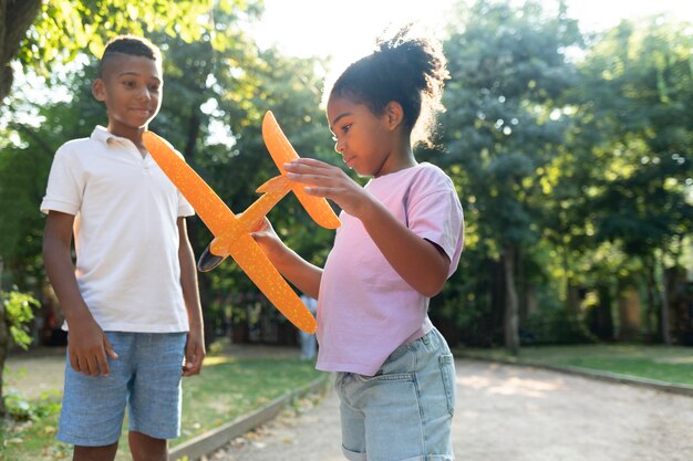 Niños de tiro medio jugando con avión