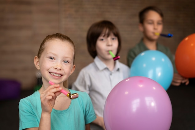 Niños de tiro medio jugando con globos