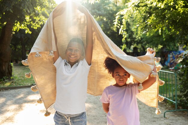 Niños de tiro medio jugando con manta