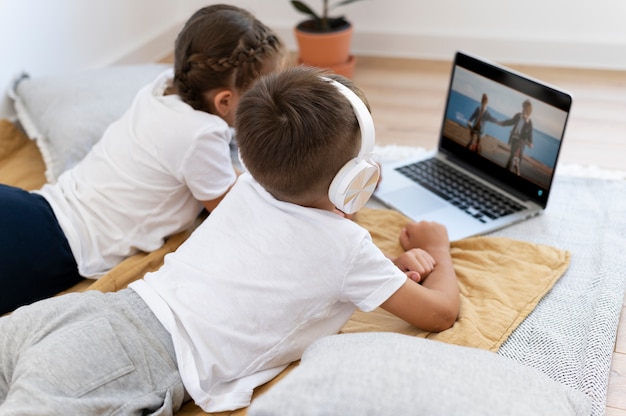 Niños de tiro medio con laptop en el interior