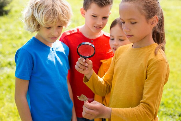 Niños de tiro medio con lupa