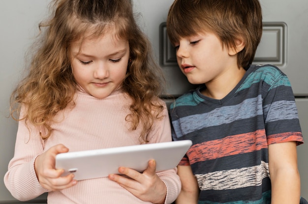 Niños de tiro medio mirando tableta