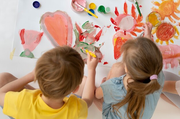 Niños de tiro medio pintando juntos