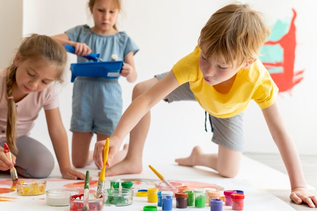 Niños de tiro medio con pintura