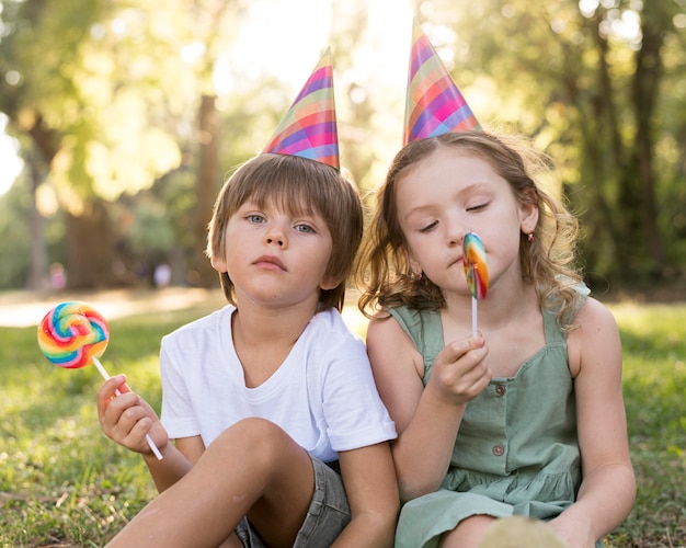 Niños de tiro medio con piruletas