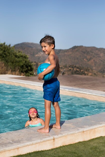 Niños de tiro medio en la piscina