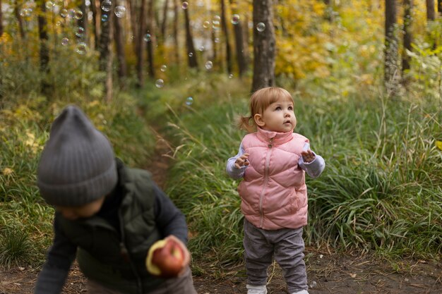 Niños de tiro medio que pasan tiempo en la naturaleza.