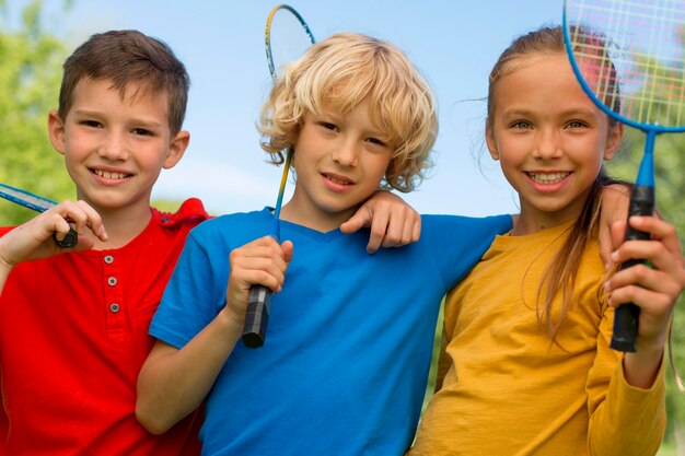 Niños de tiro medio con raqueta de bádminton