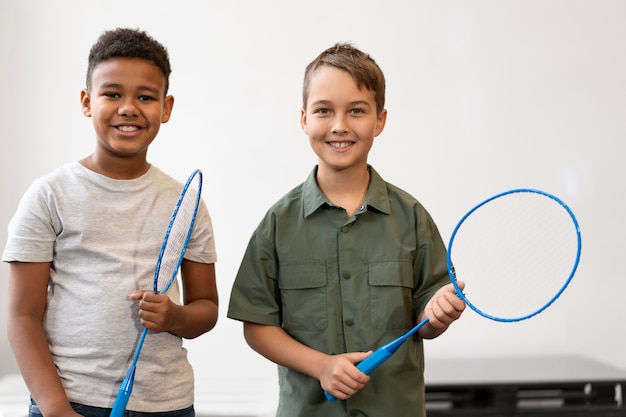 Niños de tiro medio con raquetas