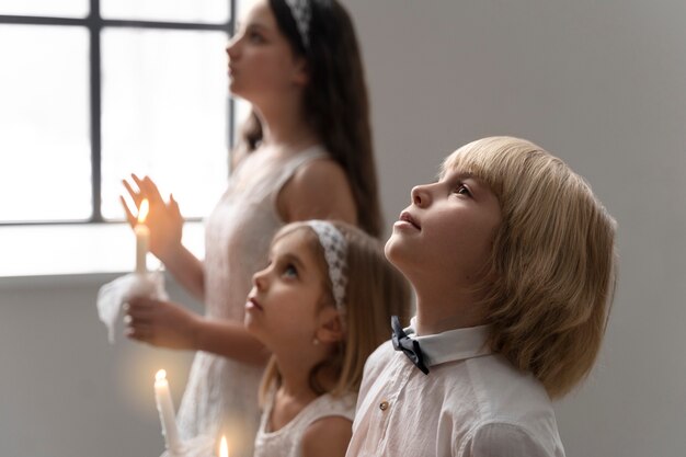 Niños de tiro medio rezando juntos