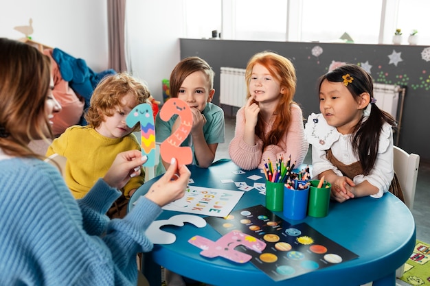 Niños de tiro medio sentados juntos en la mesa