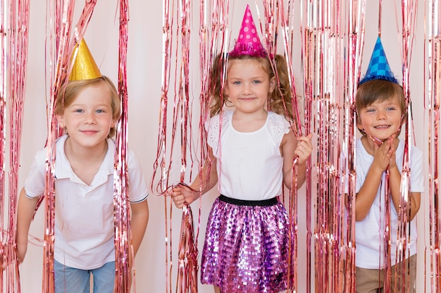 Foto gratuita niños de tiro medio con sombreros de fiesta