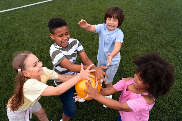 Niños de tiro medio sosteniendo globos