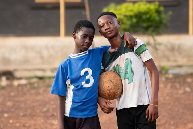 Niños de tiro medio sosteniendo pelota