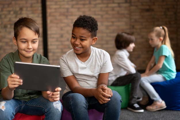 Niños de tiro medio con tableta