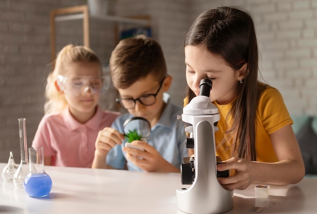 Niños de tiro medio trabajando en la mesa