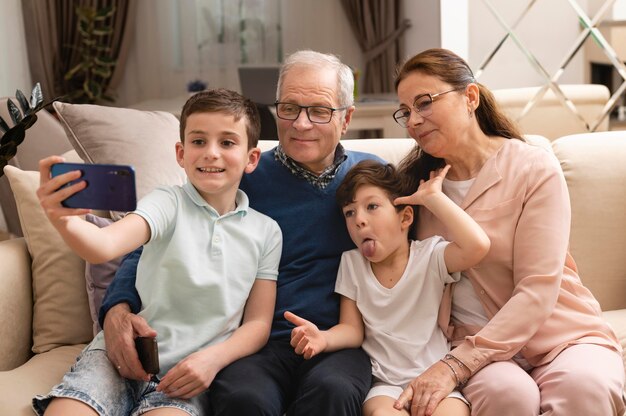 Niños tomando un selfie con sus abuelos en el sofá