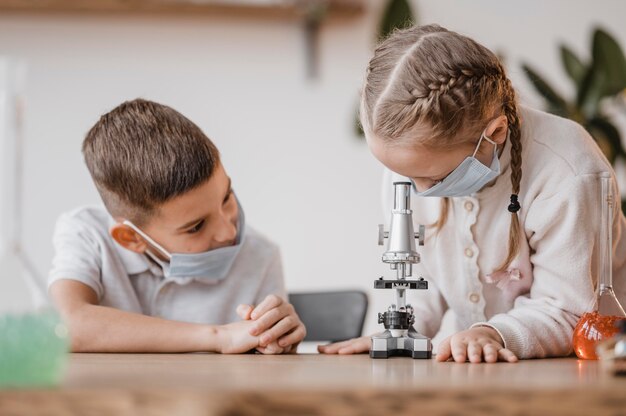 Niños usando un microscopio para aprender ciencia.