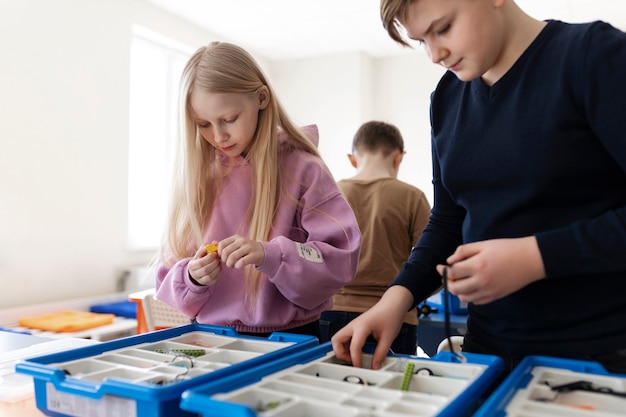 Foto gratuita niños usando partes electrónicas para construir un robot