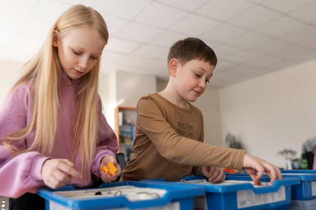 Niños usando partes electrónicas para construir un robot