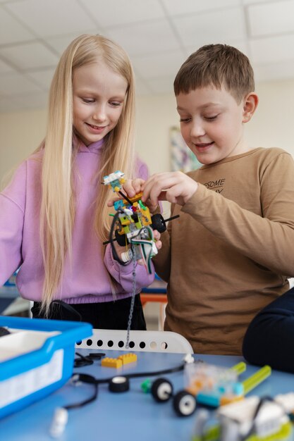 Niños usando partes electrónicas para construir un robot