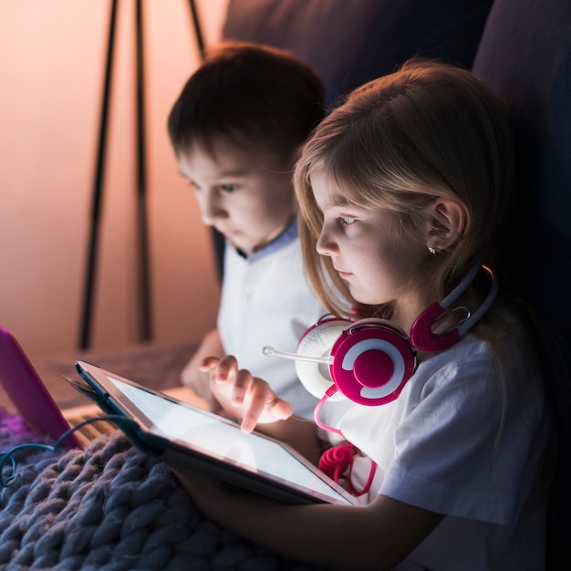 Niños usando tablet y portátil