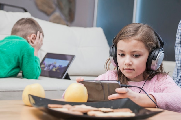 Niños usando tecnologías en la sala de estar