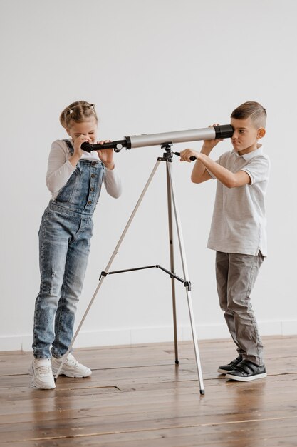 Niños usando un telescopio en clase.