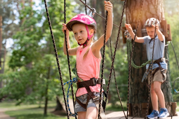 Niños valientes divirtiéndose en un parque de aventuras.