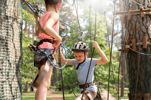 Niños valientes divirtiéndose en un parque de aventuras.