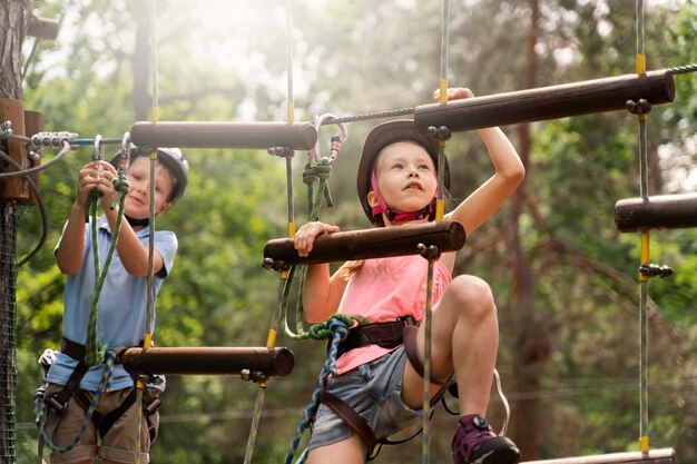 Niños valientes divirtiéndose en un parque de aventuras.