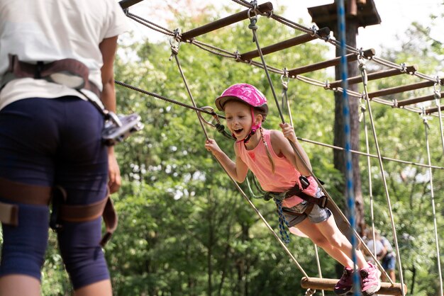 Niños valientes divirtiéndose en un parque de aventuras.