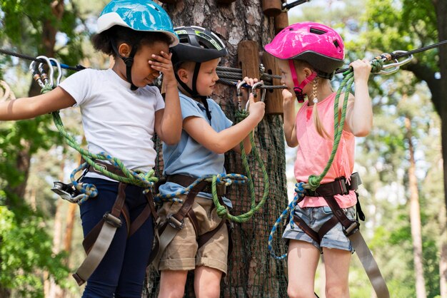 Niños valientes divirtiéndose en un parque de aventuras.