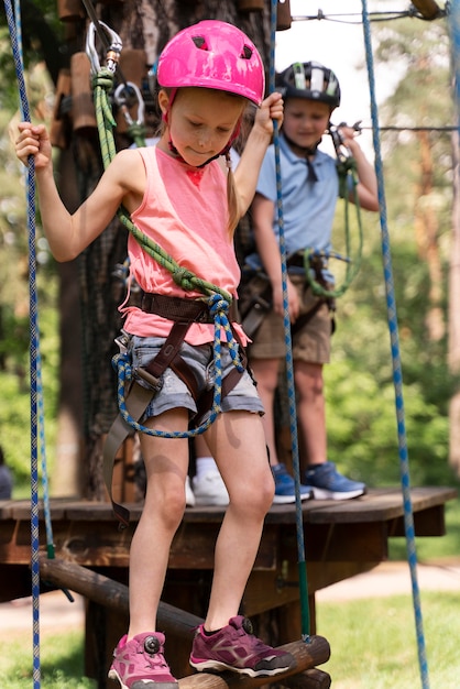 Niños valientes divirtiéndose en un parque de aventuras.