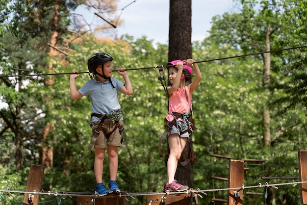 Niños valientes divirtiéndose en un parque de aventuras.