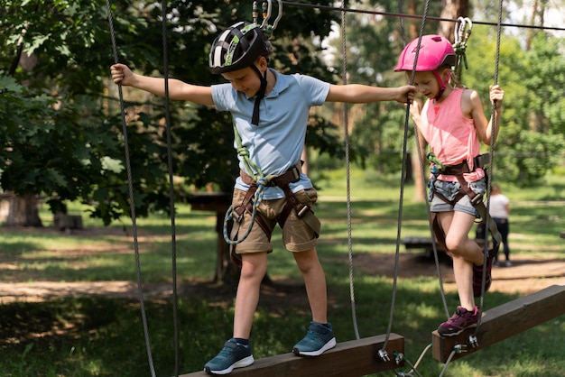 Niños valientes jugando en un parque de aventuras.